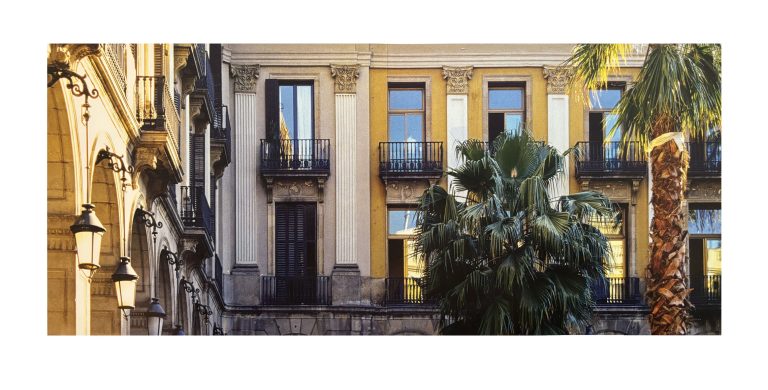 Plaça Reial: Historische Häuserfassaden mit Balkonen und Arkaden, eingerahmt von Palmen. Das warme Sonnenlicht hebt die Architektur und die mediterrane Atmosphäre hervor.