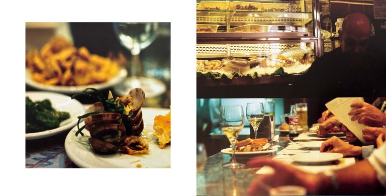 Eine Tapas-Bar in Barcelona. Links ein Teller mit Muscheln und kleinen Speisen, rechts zweigeteilt eine belebte Theke mit Gästen und darüber der Chef der Tapas-Bar vor der Fischauslage