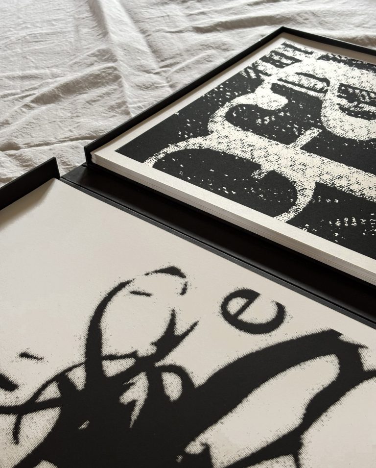 Geöffnete Mappe im Anschnitt mit schwarz-weißen Typografie-Drucken.